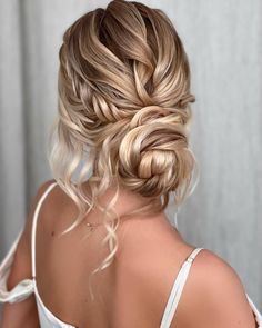 the back of a woman's head with long blonde hair in a low bun