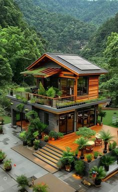 an aerial view of a house surrounded by trees and greenery in the mountainside