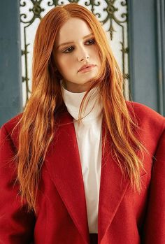 a woman with red hair wearing a red coat