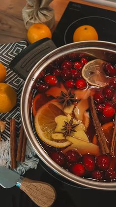 a pot filled with fruit and spices on top of a stove