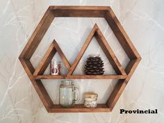 a wooden shelf that has some jars and pine cones on it, along with other items