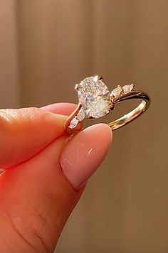 a person holding a diamond ring in their hand