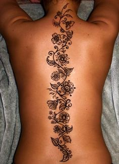 a woman's back tattoo with flowers and butterflies on it, as well as the bottom