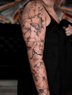 a woman's arm with flowers and butterflies on it