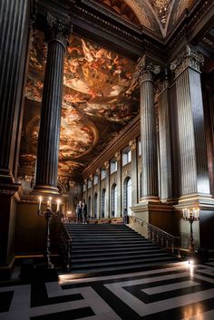 an ornate building with stairs and paintings on the walls