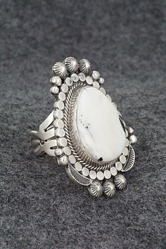 This White Buffalo and sterling silver ring was made by Navajo silversmith Tom Lewis. The back is signed and stamped sterling.Size: 9.25Length: 1 5/8"Width: 1 1/4"Free shipping on all orders! We ship with USPS and always include tracking. All orders ship within a day of payment.Returns are accepted up to 30 days after you receive your order. Just send us a message. Our shop offers cash back or store credit. The item must be returned in new condition. Southwestern Style Untreated Silver Rings, Southwestern Style White Ring Jewelry, Southwestern Style White Round Rings, Southwestern Style Oval White Rings, Handmade Southwestern White Rings, Western Style Untreated Sterling Silver Rings, Bohemian White Collectible Rings, Silver Southwestern Style Rings, Handmade White Southwestern Rings