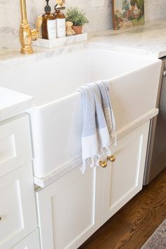 a kitchen sink with towels hanging from the faucet