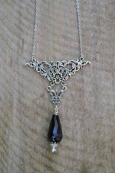 PLEASE read my shop announcement before placing an order so you know what to expect right now. Plus, when ordering from outside Europe, don't forget to provide a phone number for the courier to ensure the fastest and smoothest delivery. Royal Victorian gothic statement necklace, a really stunning piece. A black onyx agate faceted drop hangs from the bold ornate centerpiece. You don't need much more to look impressive with this, just a simple black dress will do. Fastens with a lobster clasp, cha Ornate Black Metal Necklace, Black Pendant Necklace With Intricate Design, Gothic Silver Onyx Necklace, Silver Onyx Gothic Necklace, Black Teardrop Metal Necklace, Black Metal Teardrop Necklace, Ornate Handmade Black Necklace, Gothic Teardrop Silver Jewelry, Gothic Silver Teardrop Jewelry