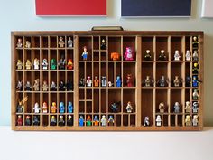 a wooden display case filled with toy figurines