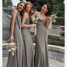 three bridesmaids in long gray dresses standing next to each other