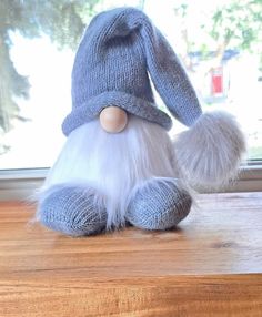 a stuffed animal with white fur and a blue hat on top of a wooden table