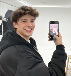 a young man taking a selfie with his cell phone