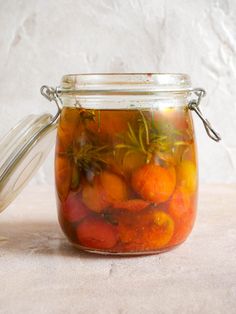 a jar filled with oranges sitting on top of a table