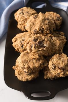 chocolate chip oatmeal cookies are on a black plate with a blue napkin