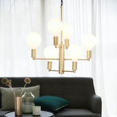 a living room filled with furniture and a chandelier hanging over the top of it