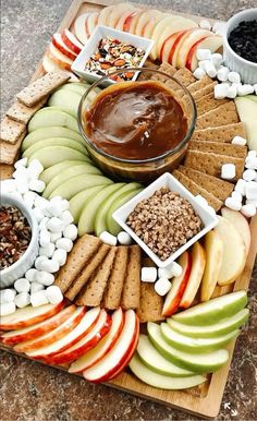 an apple platter with apples, marshmallows, crackers and chocolate