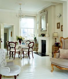 a living room filled with furniture and a fire place next to a dining room table