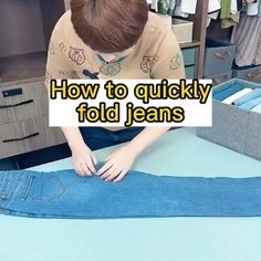 a young boy sitting at a table making jeans