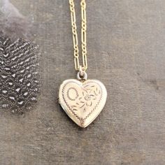 This vintage locket is engraved with a floral design on the front; the reverse is plain.  The gold filled heart, hallmarked 10k gf, opens revealing two compartments in which to place your favorite photos.  The locket hangs from a new 14k gold filled cable chain accented with tiny white pearls at the clasp.    Locket 24x21mmNecklace length 18" (45cm)✦All of our vintage lockets ship with complimentary insurance✦✤Our entire selection of lockets can be found here✤http://www.etsy.com/shop/LexiandGem? Gold Heart-cut Locket Necklace For Gift, Elegant Yellow Gold-plated Locket Necklace, Vintage Gold Heart Locket, Brass Heart Locket Necklace, Gold Heart Locket Necklace, Heart-shaped Brass Locket Necklace For Gifts, Locket Gold, Push Present, Flower Girl Necklace