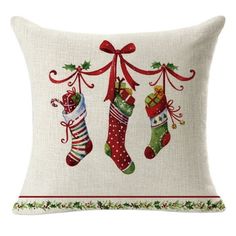 two stockings hanging from a christmas tree on a white pillow with green and red trimmings