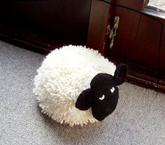 a black and white sheep laying on the floor