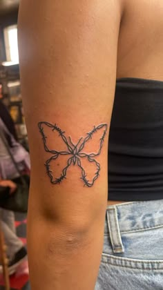 a woman's arm with a tattoo that has a butterfly on the back of it