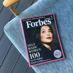 a magazine sitting on top of a blue chair next to a wooden spoon and fork