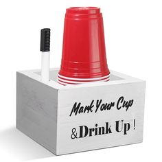 a red and white cup sitting on top of a wooden box with the words mark your cup and drink up