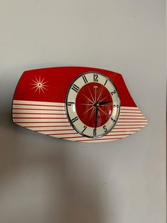 a red and white clock mounted to the side of a wall