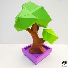 an origami tree in a purple box with green leaves on it's trunk