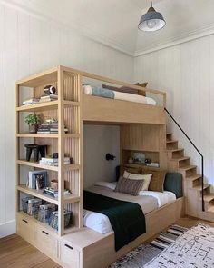 a bunk bed is built into the side of a room with stairs leading up to it