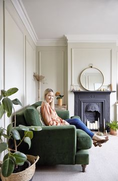 a woman sitting on a green couch in a living room