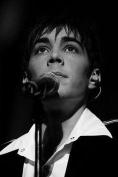 black and white photograph of a woman singing into a microphone in front of a microphone stand