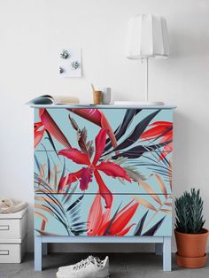 a painted dresser with flowers and plants on it