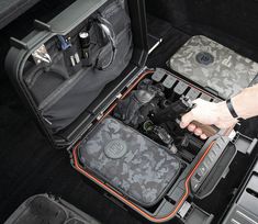 the inside of a car trunk with an open camera case on it's side