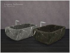 two marble sinks sitting next to each other on top of a black floored room