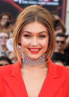 a woman wearing a red suit and choker