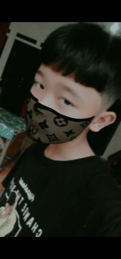 a young boy wearing a black shirt and mask