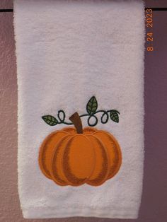 a white towel with an orange pumpkin embroidered on it