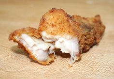 two pieces of fried food sitting on top of a wooden table next to each other