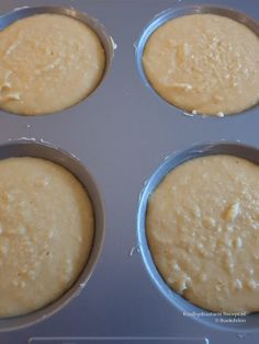 four muffins in a metal pan sitting on top of a counter