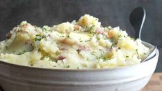 a white bowl filled with mashed potatoes on top of a wooden table