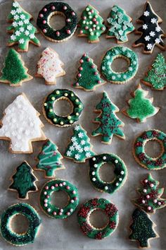 decorated christmas cookies arranged in the shape of trees and wreaths on a baking sheet