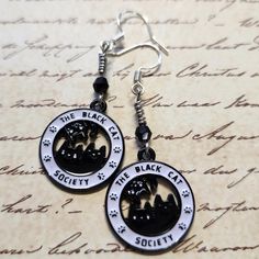 Enamel Black Cat Society Dangle Earrings with Black Faceted Glass Bead. Dangle approx 2".  Hypo-allergenic sterling silver ear wires. Black Hypoallergenic Sterling Silver Jewelry, Black Cat Design Drop Earrings, Black Hypoallergenic Adjustable Earrings, Black Hypoallergenic Metal Earrings, Hypoallergenic Black Metal Jewelry, Witchy Tips, Faceted Glass, Lebanon, Glass Bead