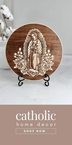 a wooden plaque with an image of the virgin mary on it and text catholic home decor shop now