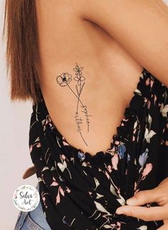 the back of a woman's shoulder with a flower tattoo on her left side