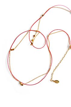 A multi wearable style made of a delicate 14k gold filled flat cable chain (1mm x1.3mm) with a 100% nylon fine cord in a bright ruby red color. The nylon cord & chain are joined with 14k gold filled crimps. Mini 14k gold vermeil cube beads are randomly strung onto the chain. The total length is 21", including the 2 1/4" chain extension for size adjustability. The closure is a 14k gold filled spring ring clasp. We named this style the "Love Chain" because it is the perfect piece to gift to a love Adjustable Gold Necklace With Silk Cord, Adjustable Yellow Gold Multi-strand Jewelry, Adjustable Multi-strand Yellow Gold Jewelry, Red Adjustable Lariat Necklace, Gold Silk Cord Necklaces As Gift, Gold Silk Cord Necklaces For Gifts, Gold Silk Cord Necklace For Gift, Red Minimalist Jewelry With Adjustable Cord, Ruby Red Color