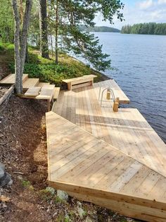 a wooden dock sitting on the side of a lake