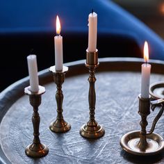 three candles are sitting on a metal tray