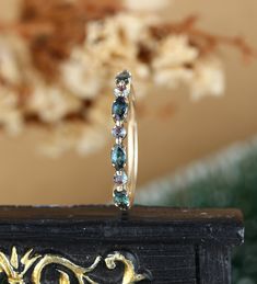 a close up of a ring on top of a wooden table with flowers in the background